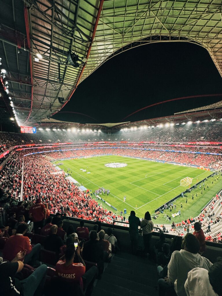 A thrilling football match at Estádio da Luz in Lisbon, capturing the vibrant atmosphere of the crowd and illuminated field.